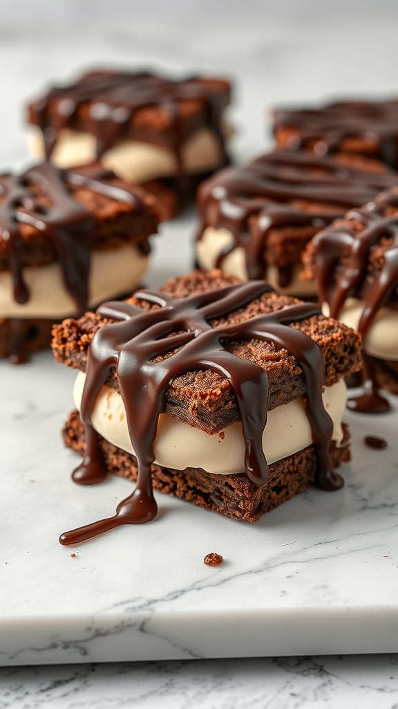 Brownie ice cream sandwiches drizzled with fudge sauce on a marble surface.
