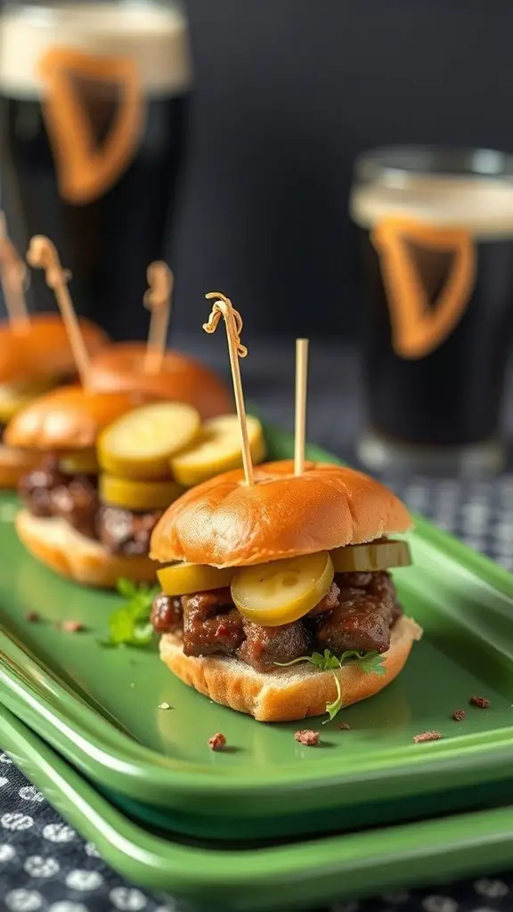 Guinness Stout Beef Sliders on a green platter with pickles and glasses of stout in the background.